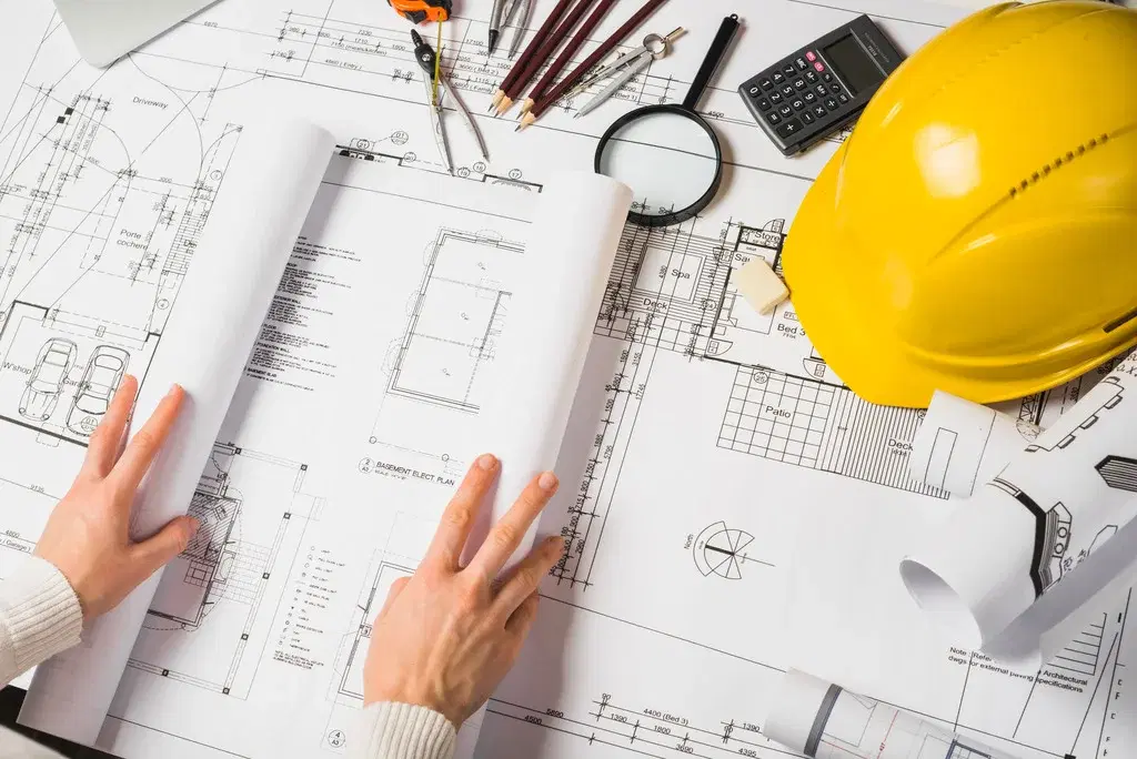Construction plans, calculator and hard hat for job costing